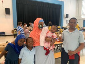 Beloved Community Council Representative Fowsia with her family at ICS food co-op
